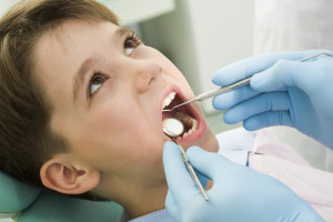 young boy opening his mouth during dental checkup